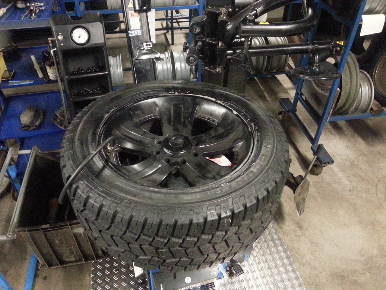 A wheel and tyre on the tyre machine in a workshop